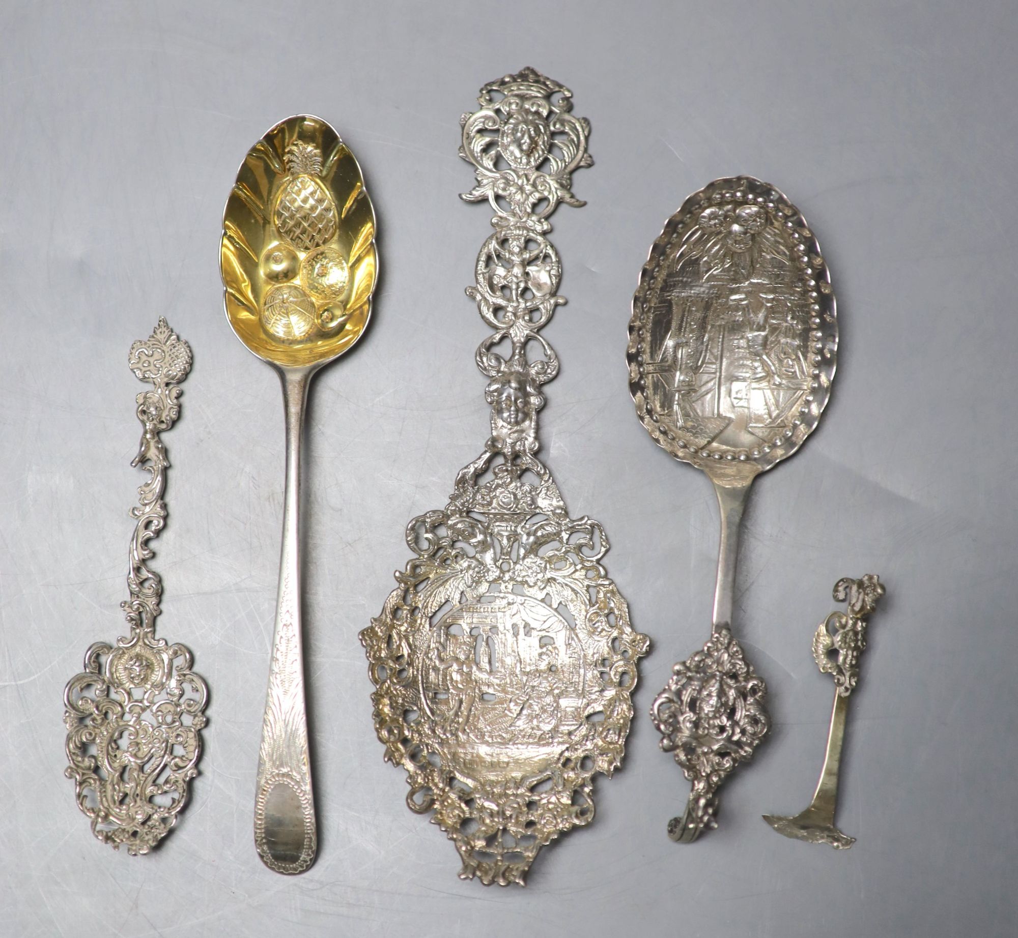 Three white metal decorative spoons and a single berry spoon